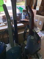 Eureka and Hoover units side by side showing bodies, handles and cords