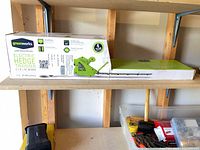 Full view of boxed Greenworks hedge trimmer on shelf