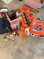 Mixed Halloween items including hats, lights, pails, bags and small decor spread on floor