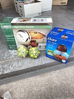Boxed Home Essentials high dome roaster, boxed Oster Top Chop chopper, ceramic lemon motif lidded jar with spoon