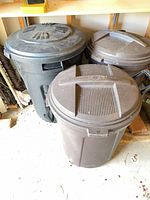 Top view of three plastic trash cans with lids