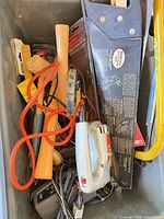 Bin containing jig saw, hand saw, mallet, hacksaw, files, cords