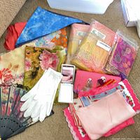 Overview of scarves, gloves, fan, mirror, wallet and pouch on floor