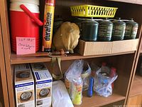 Overall view of shelves showing cooler, Duraflame matches, propane cylinders, burners and accessories