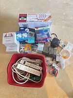 Entire lot with bulbs, filters, batteries, camera, alarms, power accessories in red bin