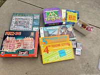 Group shot showing all boxed games, puzzles, tracing letter sets, playing cards, and magnetic letters