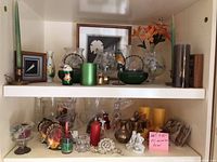 Both shelves with assorted glass, metal, candles, figurines