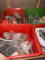 multiple totes containing bagged and loose rock specimens