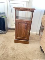 Front view of oak veneer nightstand showing open shelf and cabinet door with brass knob