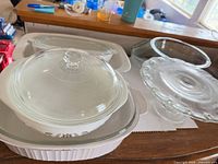Stacked casseroles showing gold floral dish with lid inside large ribbed casserole, adjacent mixing bowl and cake stand