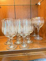 Group of etched tree wine glasses on shelf