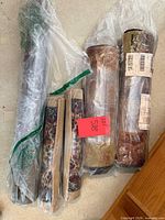 Five rolled doormats in plastic wrap on floor