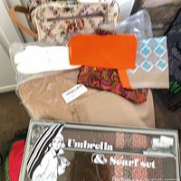 group shot showing tapestry bag, gloves, orange scarf, paisley scarf and boxed umbrella set