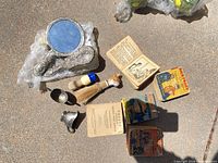 all lot items laid out: ornate mirror, brush, two shaving brushes, metal creamer, six children’s paperback books
