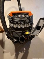 Top view showing cord wrap, handle, hose ports, accessory nozzle