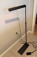 Full view of Slimline Task floor lamp standing, showing adjustable shaft and shade