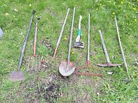 All eight garden tools laid out on grass