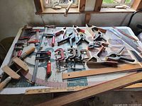Overall view of assorted clamps, yardstick and straightedge on table