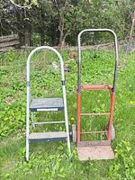 Dolly and folding ladder standing upright on grass
