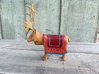 Left side view of wooden reindeer showing painted blanket and antlers