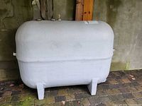 Full view of horizontal fibreglass oil tank showing size, shape, legs, and fittings