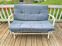 Front view of metal glider loveseat with cushion