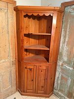 Full view of pine corner cabinet with upper open shelves and lower doors