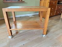 Full view of pine TV stand showing top, shelf and casters