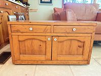 Front view showing drawers, doors, knobs, pine construction