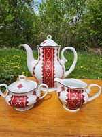Teapot, sugar bowl and creamer displayed outdoors showing full pattern and shapes