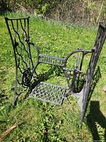 Overall view of Singer cast-iron treadle base showing side panels, pedal, and cross brace logo