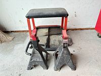 Two jack stands and rolling seat grouped together