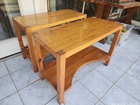 Two matching pine tables with lower shelves