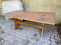 Full view of wooden trestle harvest table on stone patio
