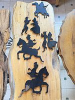 Group of five black wooden silhouette figures on board