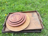 Stacked trays with nested round platters on grass