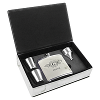 Open gift box showing flask, two shot glasses, funnel, black foam insert and velveteen lining