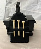 Actual golf bag tag with four boxed units behind