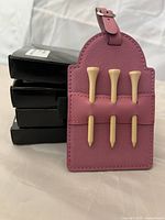 Front view of tag showing three tees inserted and stack of boxes