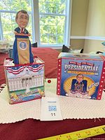 Toy popped up from tin showing Bush figure, tin graphics and original box