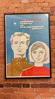 Full view of framed Soviet poster hanging on brick wall