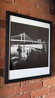 Framed black and white photograph of Albert Bridge on brick wall