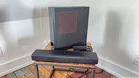 Soundbar, subwoofer and power supply on table