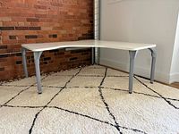 Overall view of L-shaped desk against brick wall