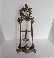 Front view of ornate brass easel stand