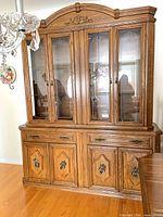 Front view showing full two-piece china cabinet with glass doors, lower doors, drawers, and arched top