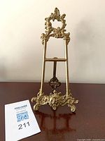 Front view of ornate brass easel stand showing decorative details