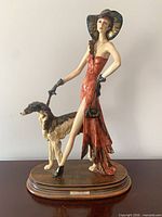 Front view of porcelain flapper with borzoi on wood base