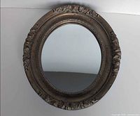 Full front view of oval ornate mirror