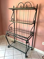 Front view of wrought iron baker's rack showing full structure and shelves